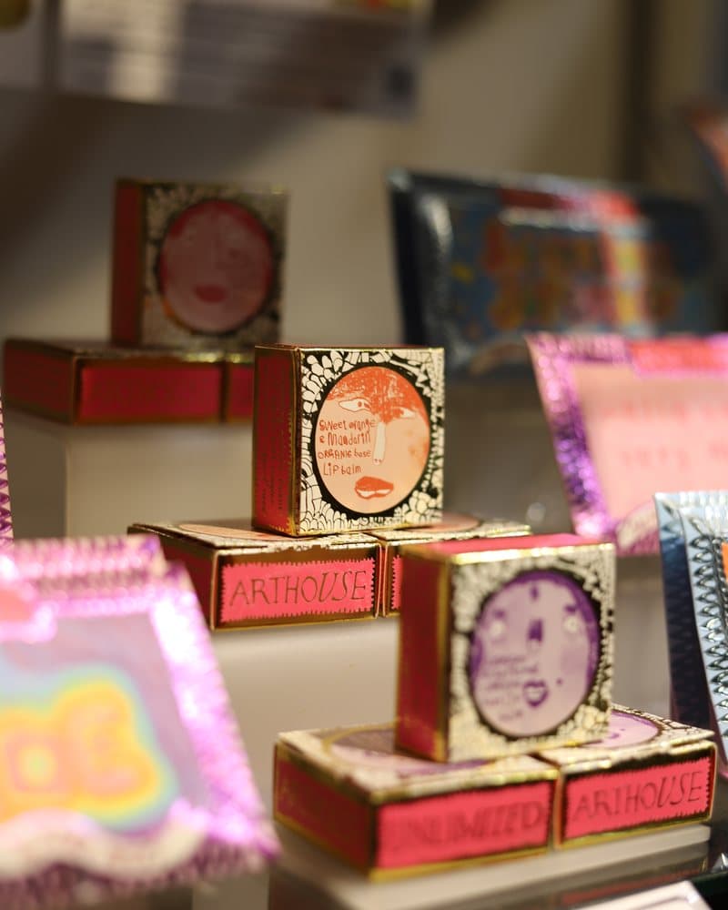 Brightly illustrated greetings cards and small gifts on a shelf.