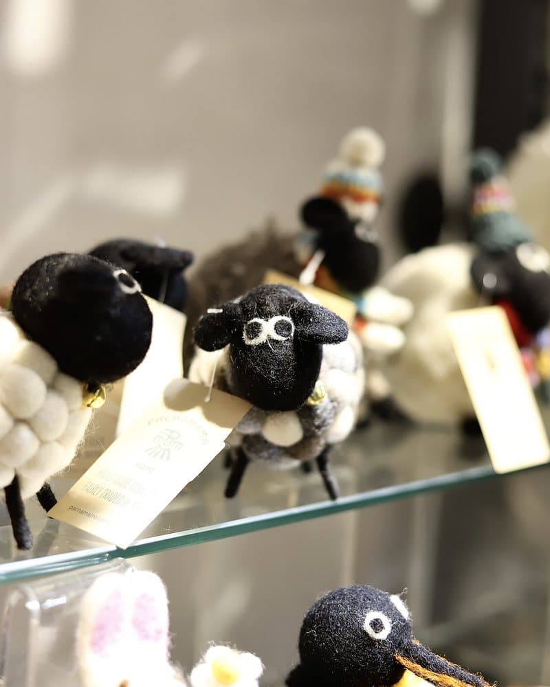 Small handmade felt animals on a glass shelf.