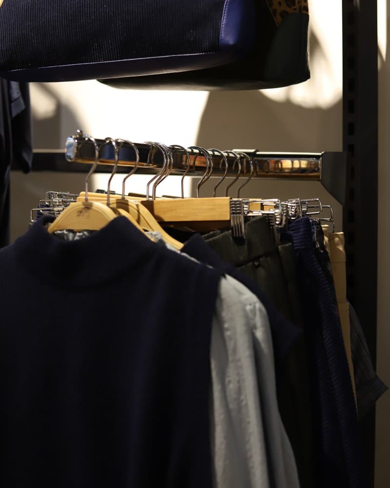 Navy and grey knitwear hanging on a rail inside Oberon Essentials.