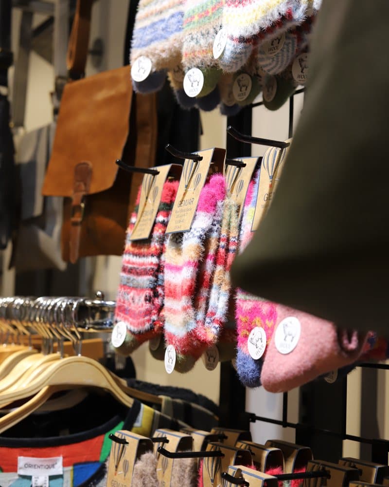 Patterned wool socks and gloves hanging on a display rail.